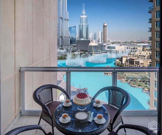 красивый вид с балкона небоскреба на башню Бурдж-Халифа и фонтаны в Дубае