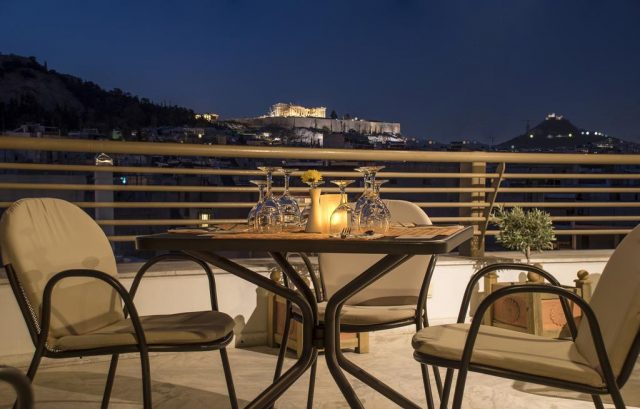 красивый вид на ночной Акрополь в Афинах с балкона отеля